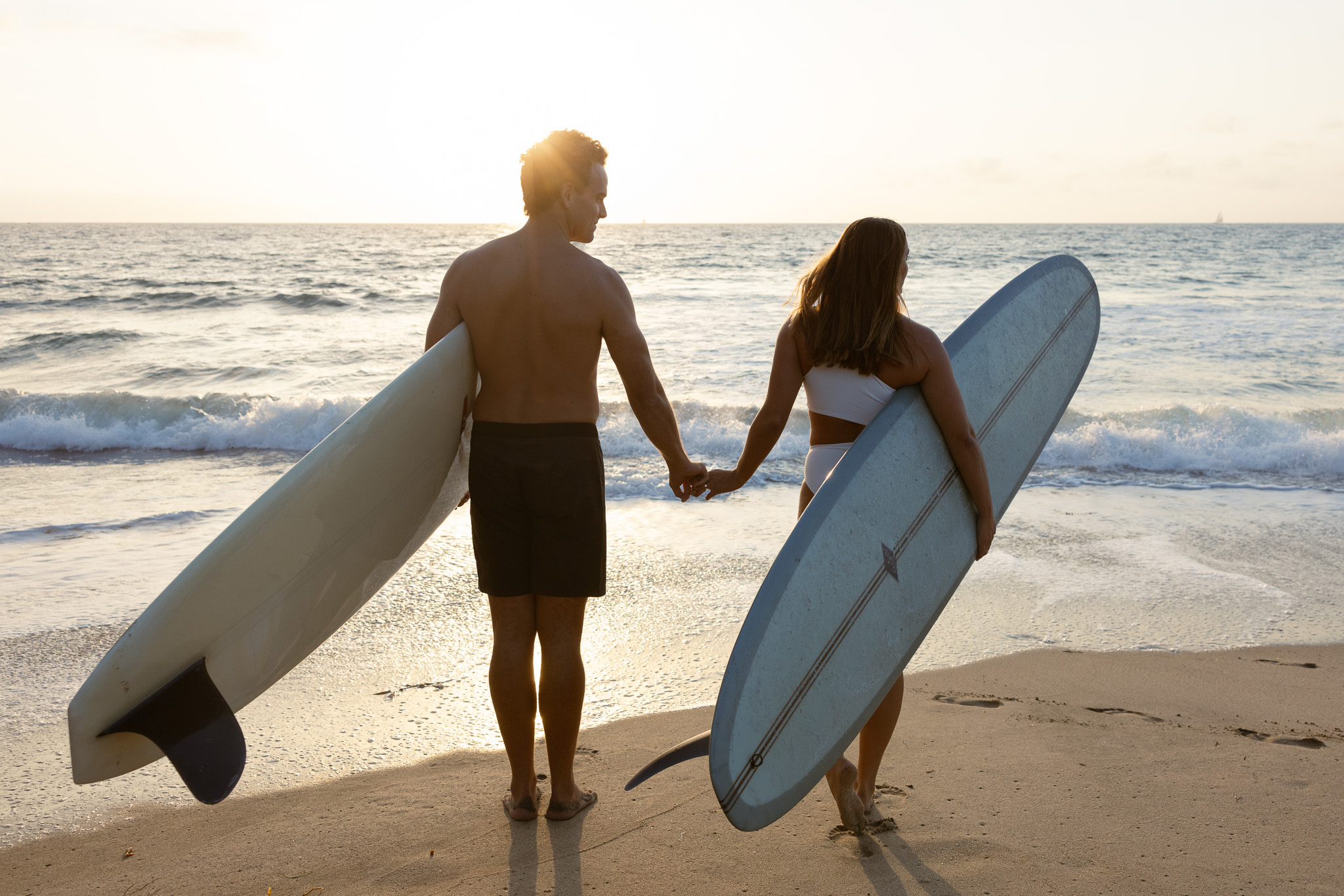 engagement photograph of a couple surfing at the beach in Los Angeles