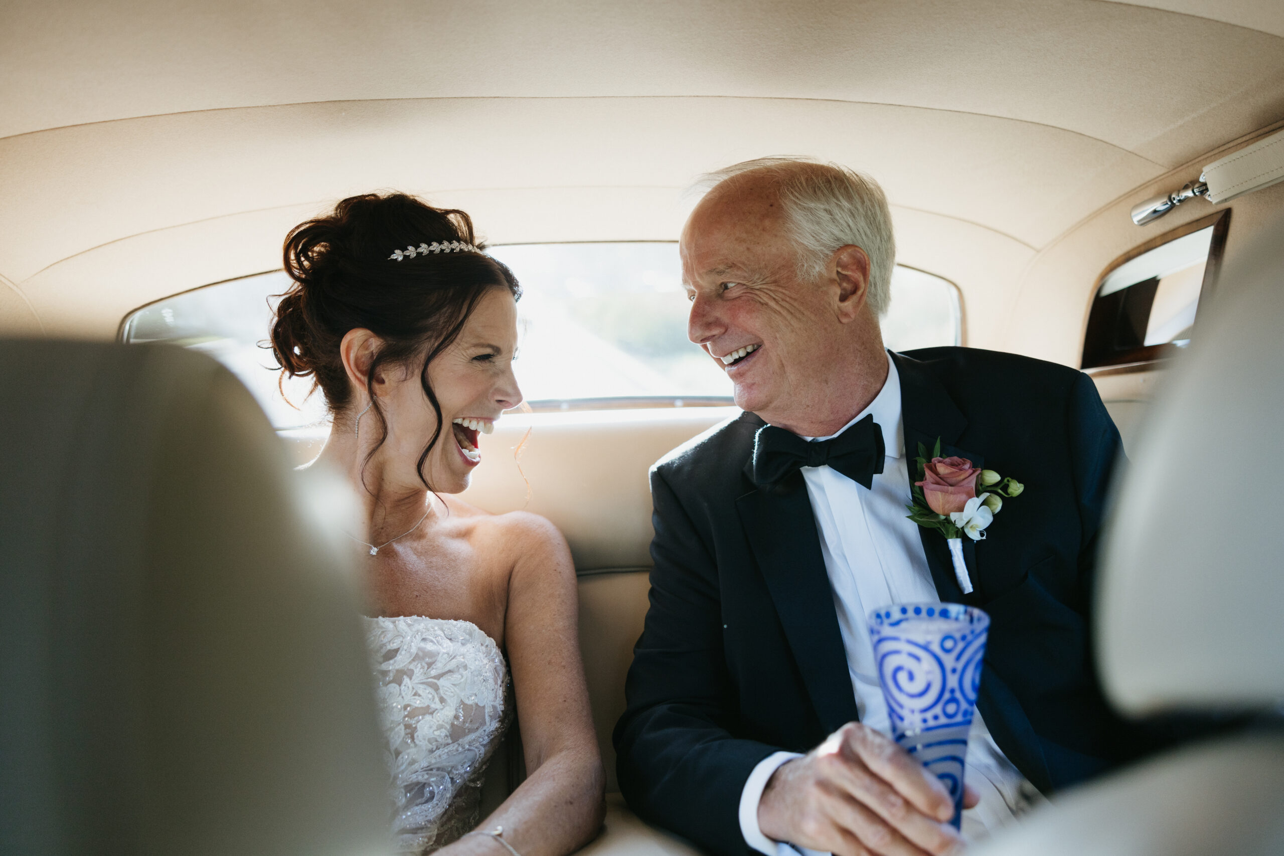 Documentary-style wedding photography of bride and groom in vintage getaway car captured by Los Angeles film photographer