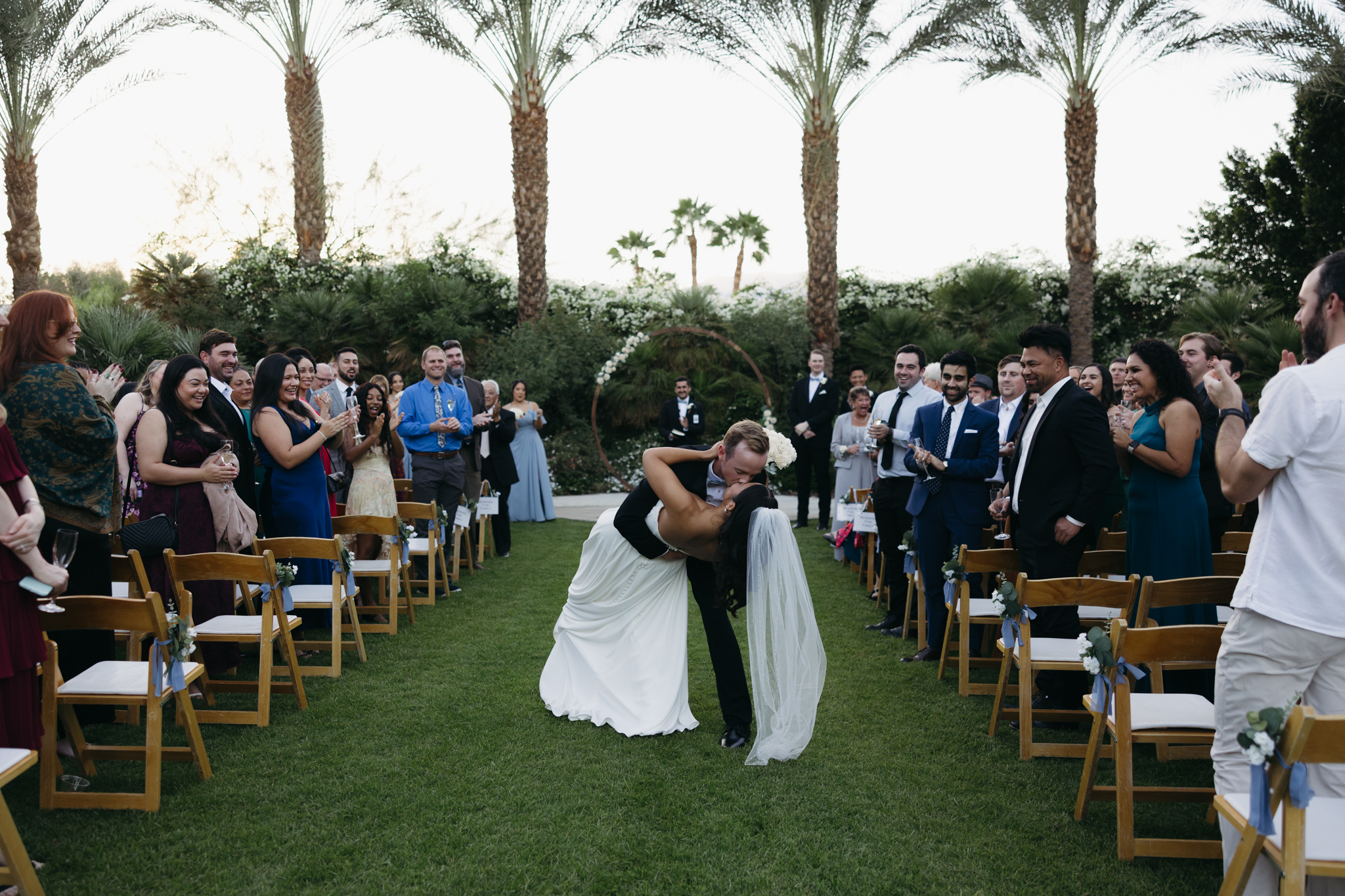 A just-married couple kissing during their ceremony at their Palm Springs wedding captured by California candid wedding photographer.